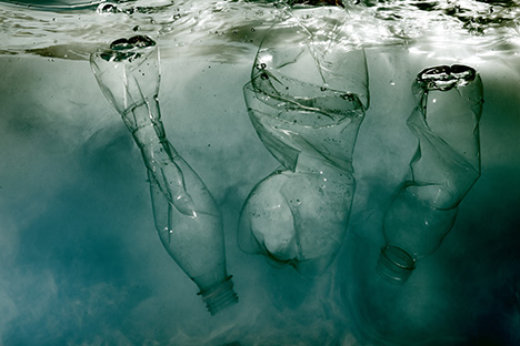 Tres botellas plásticas tiradas en un estuario contaminando el medio ambiente. 
