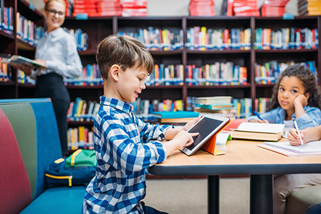 Niños estudiando en una biblioteca. 