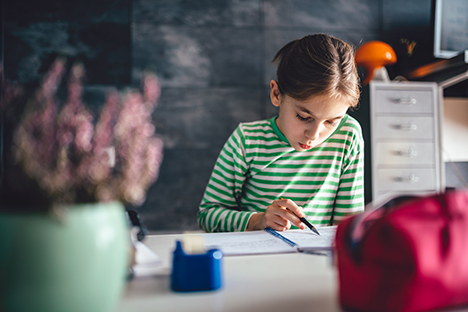 Una niña practicando su comprensión lectora en casa. 