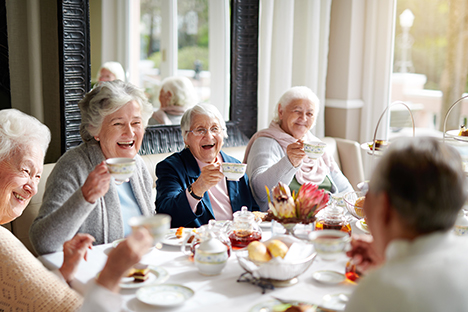 Un grupo de abuelitas tomando té y riéndose. 