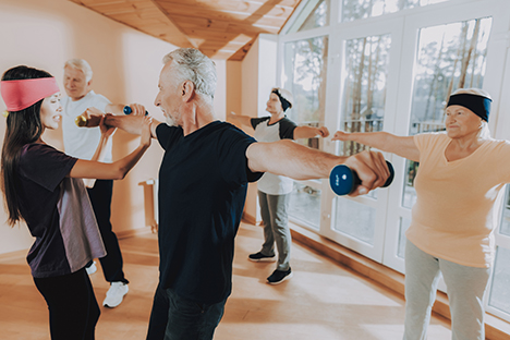 Adultos mayores hacen ejercicios físicos para mejorar su fuerza, su equilibrio y su capacidad para caminar. 