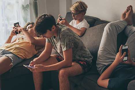 Un grupo de jóvenes revisando sus redes sociales. 