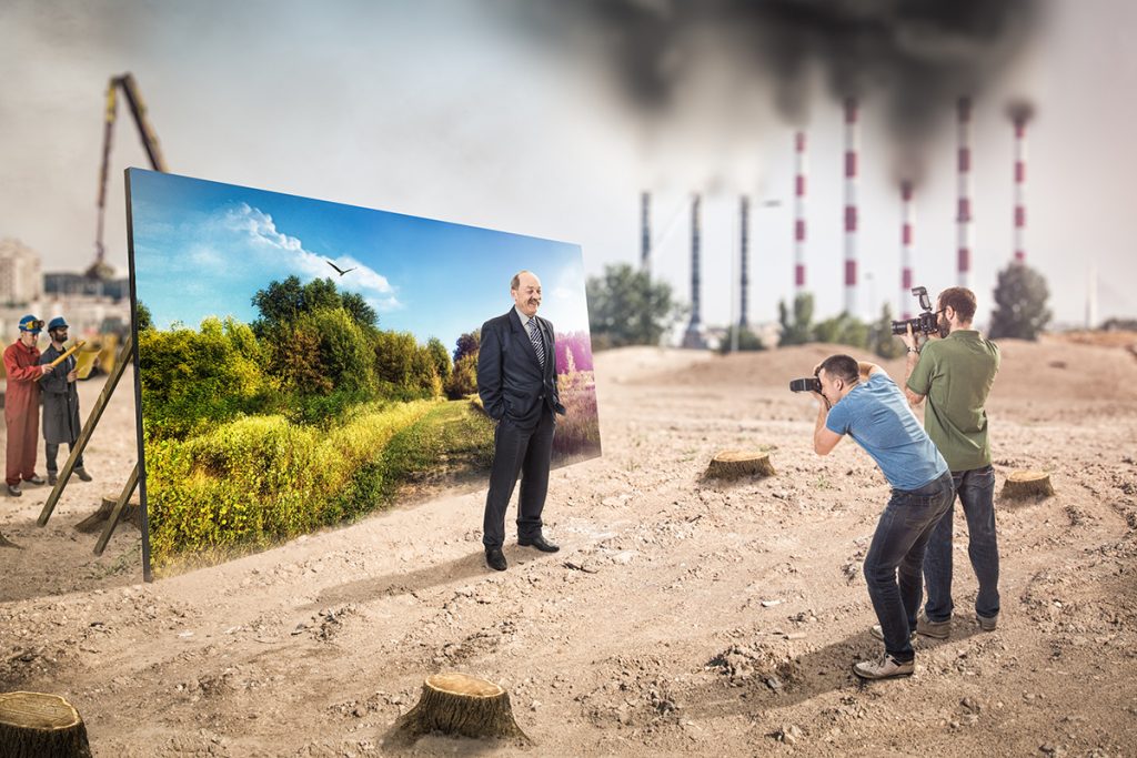 Representación del social washing, donde un empresario es fotografía frente una pancarta de un bosque. Al fondo el mundo es gris, sin árboles, contaminado. 