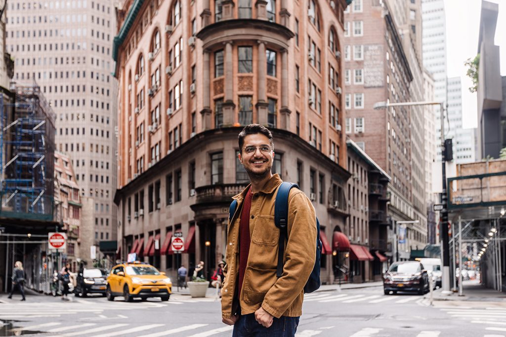 Retrato de un hombre sonriendo feliz en las calles de Manhattan Downtown, Nueva York, EE.UU.